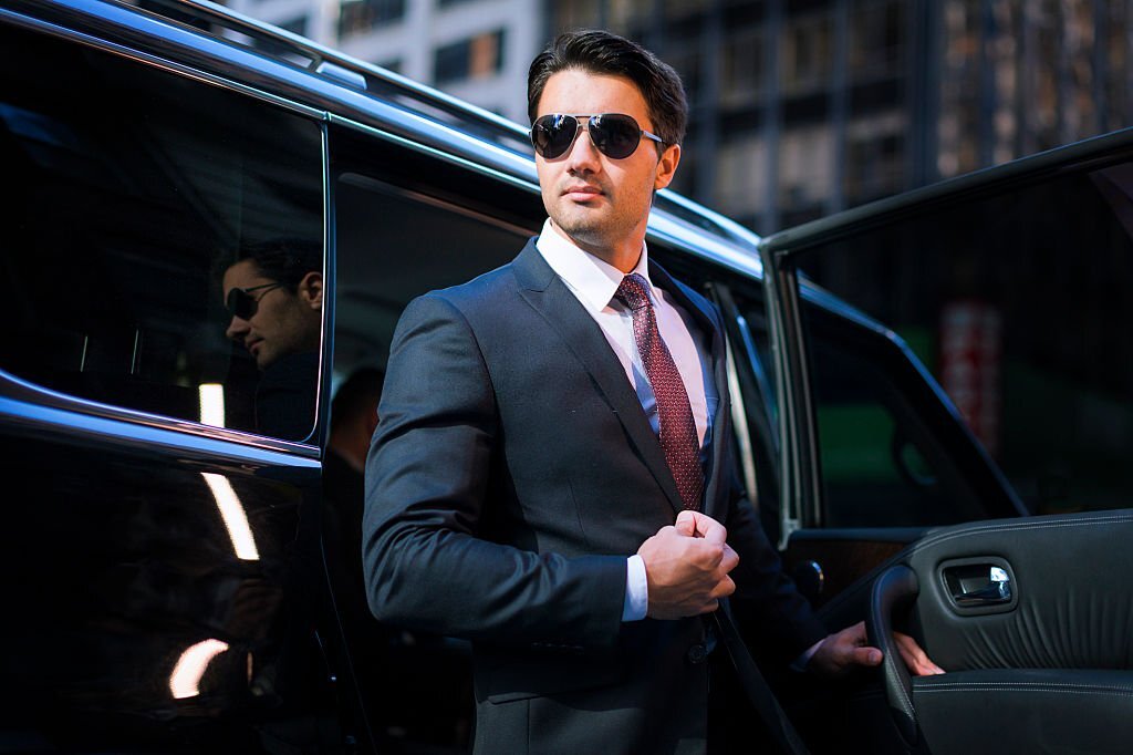 businessman arriving in executive car wearing a suit