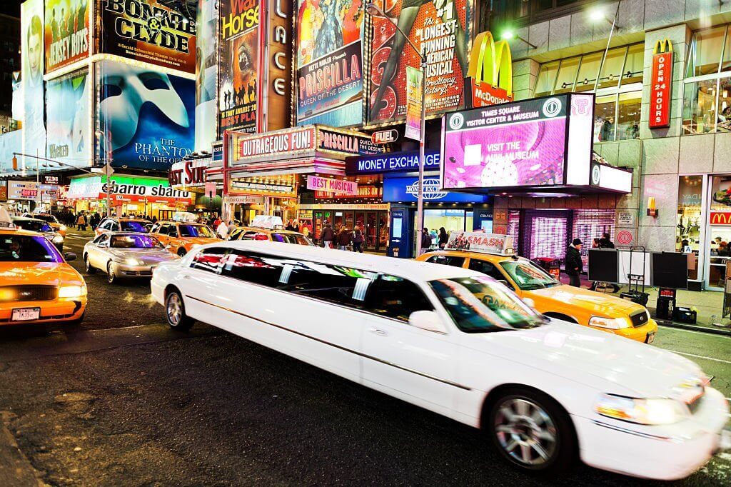 A luxurious limousine navigating through heavy traffic on a bustling city street.