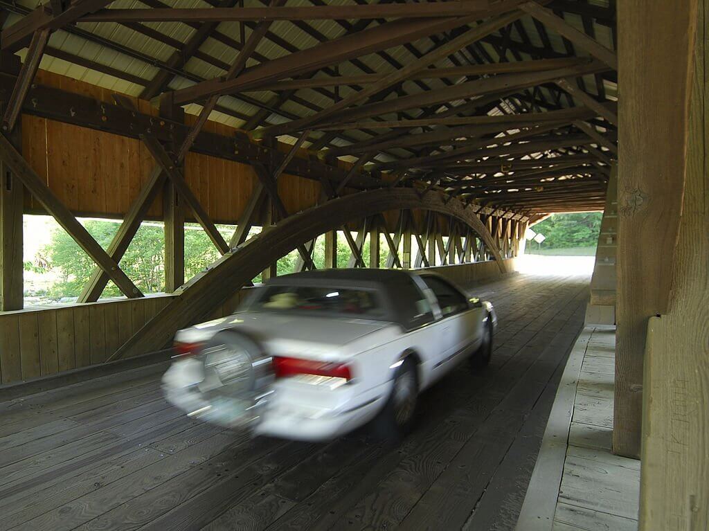 A luxurious limousine parked in front of scenic New Hampshire landscapes.