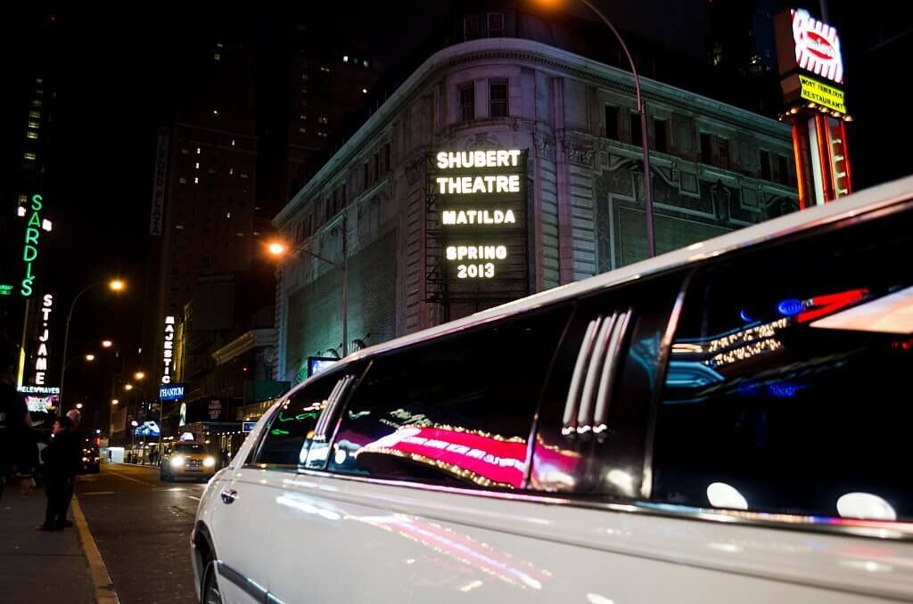 Image of a luxurious limousine parked outside the Shubert Theatre