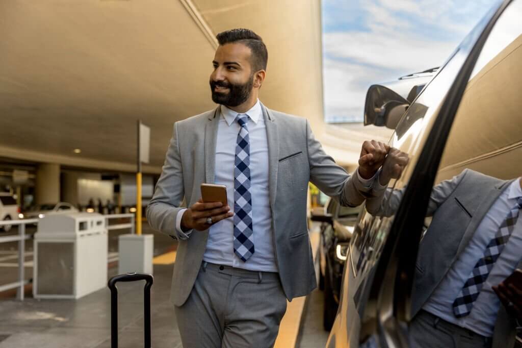 photography of a man using a smart phone while riding in an limousine.