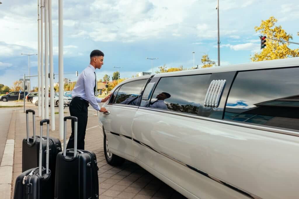 chauffeur is closing the door of the limousine