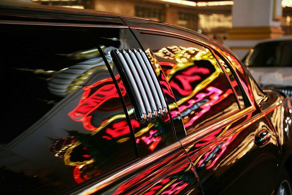 Neon sign reflected in limousine 