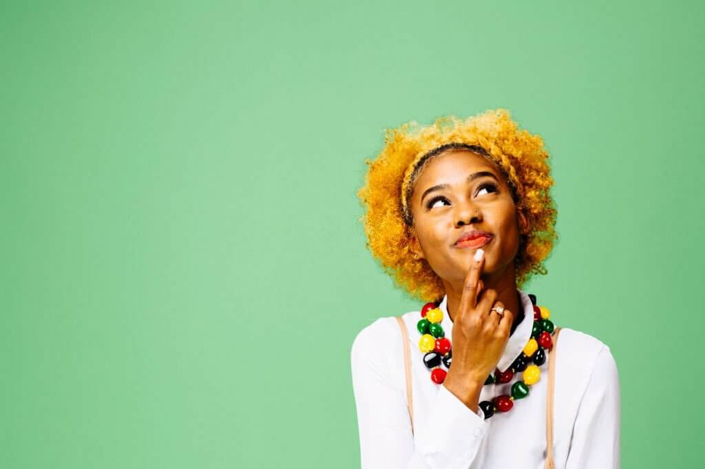 Young woman thinking and looking up, isolated on 