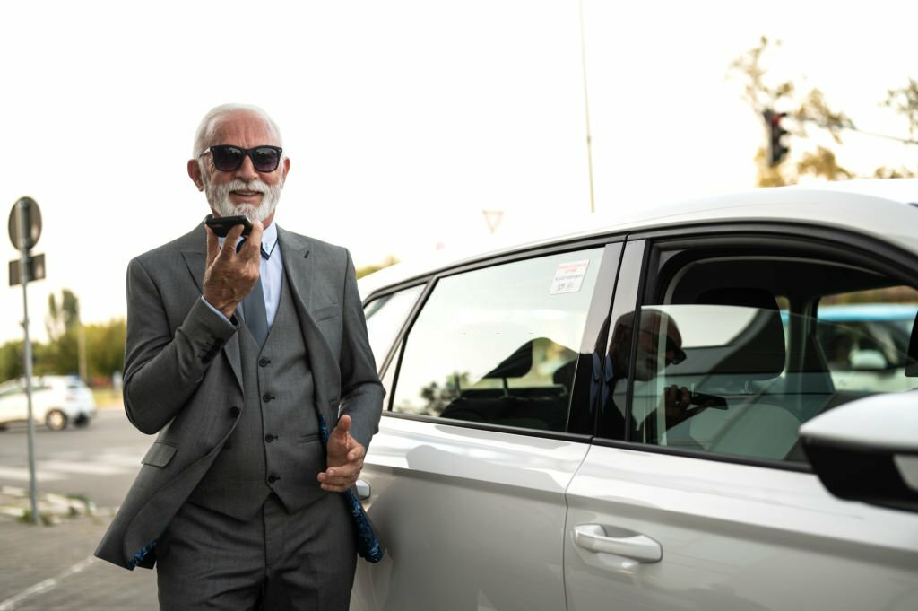 standing next to his car, having a phone call.